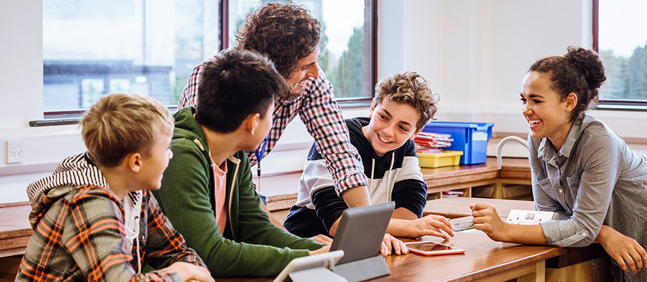 Lehrer mit Schüler:innen im Klassenzimmer